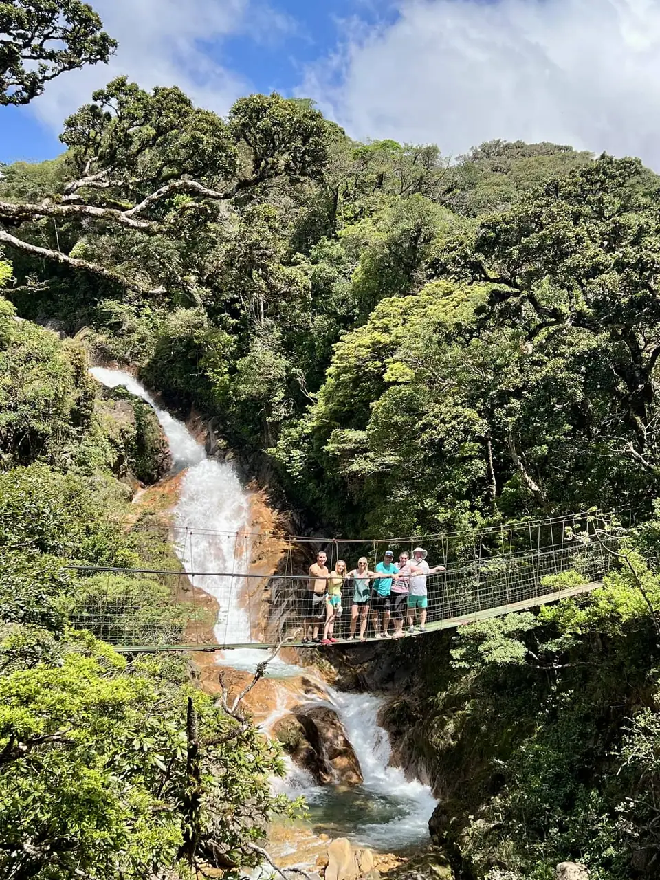 Visitors on a hanging bridge above a waterfall at Las Hornillas
