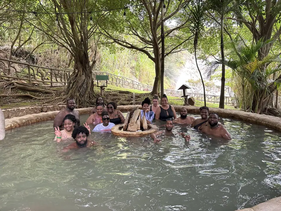 Visitors soaking in a hot spring pool under trees at Las Hornillas
